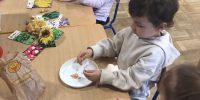 Dzieci sprawdzają dotykiem strukturę ziaren oraz małych warzyw takich jak rzodkiewka.