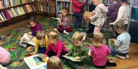 Grupa dzieci w bibliotece ogląda książki