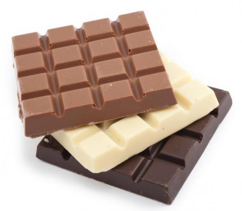 kostki czekolady w kolorze brązowym, białym i ciemnym - mleczna, biała i gorzka ułożone jedna na drugiej